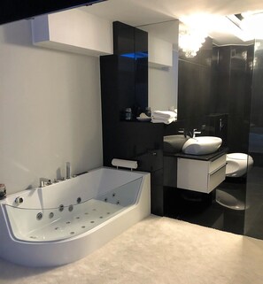 Un baño moderno con una bañera independiente, un tocador con lavamanos y un inodoro.