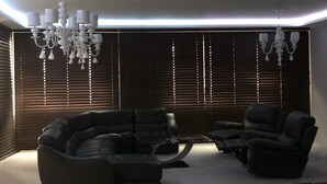 A modern living room with a sectional sofa, two armchairs, a coffee table, and a chandelier.