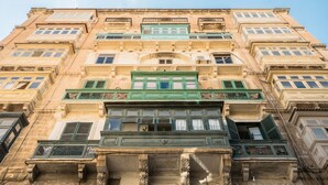 Ein mehrstöckiges Gebäude mit aufwendigen architektonischen Verzierungen, darunter dekorative Balkone und große Fenster.