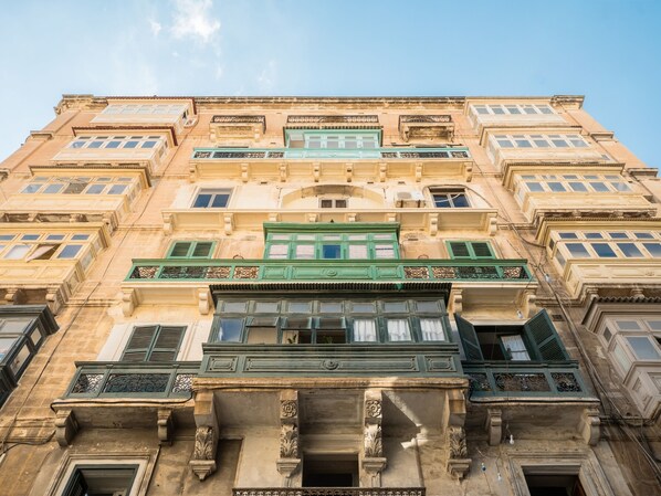 A multi-story building with ornate architectural details, including decorative balconies and large windows.