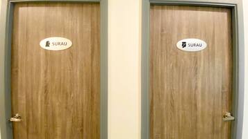 Two wooden doors with signs indicating 'SURAU' and a restroom symbol.