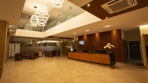 A modern hotel lobby with a reception desk, seating area, and a large glass wall. - AZ Hotel & Serviced Apartments (Labuan)