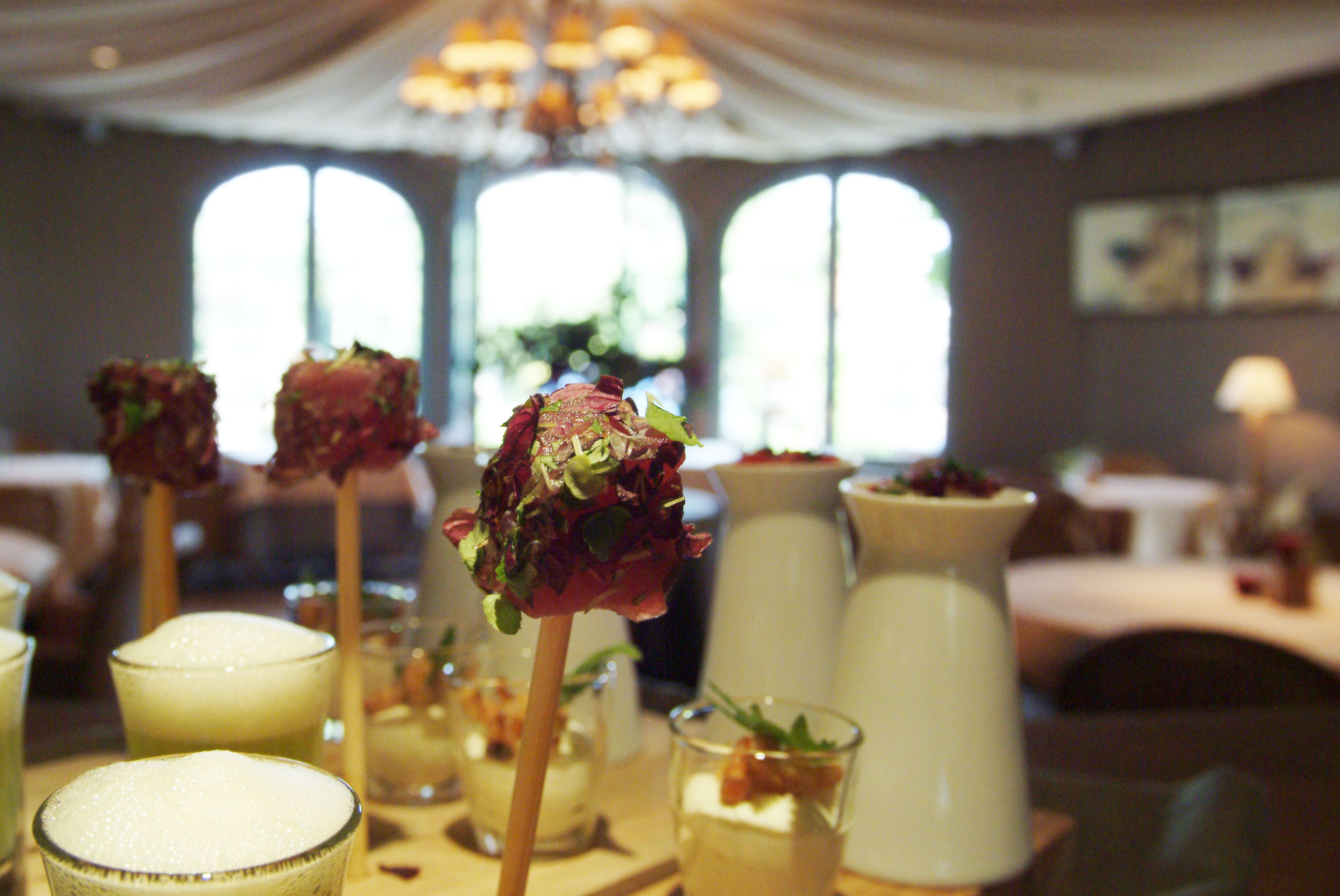 A dining area with tables set for a meal, featuring various dishes and drinks.