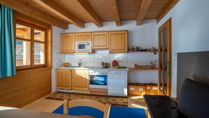 Eine Küche mit Holzausstattung, einer Mikrowelle, einem Backofen und einem Geschirrspüler.