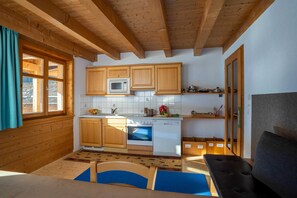 Una cocina con gabinetes de madera, microondas, horno y lavavajillas.
