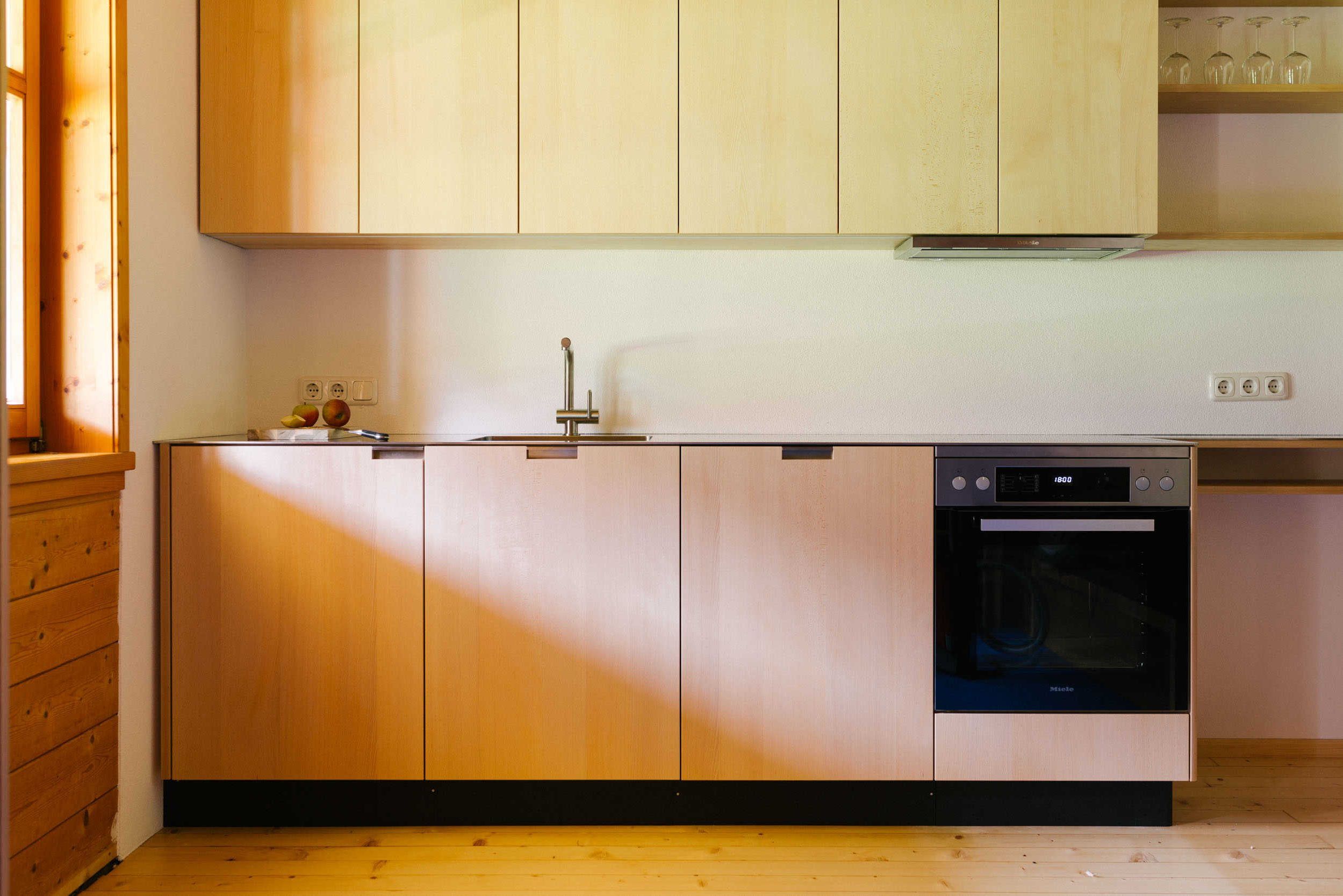 A kitchen with wooden cabinets, a dishwasher, and a wine rack.