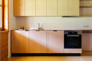 Una cocina con armarios de madera, lavavajillas y una estantería para vinos.