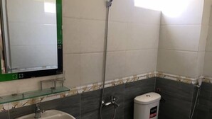 A bathroom with a sink, toilet, and shower. - Dinh Sa Ly Son Hotel (Ly Son)