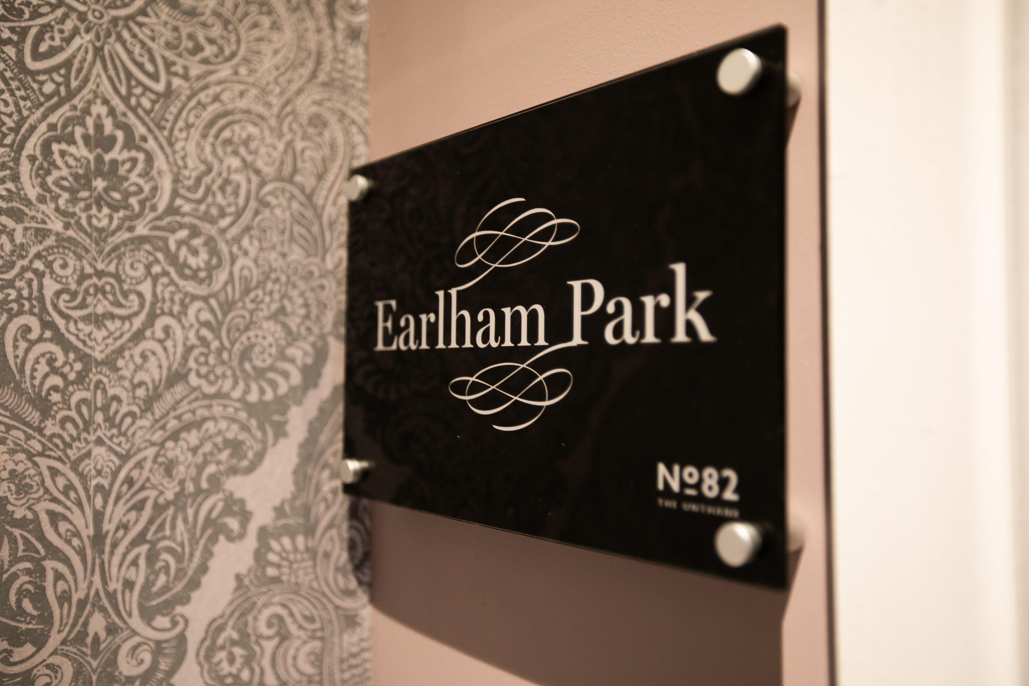 Un panneau indiquant « Earlham Park » et « n° 82 » est fixé à un mur.