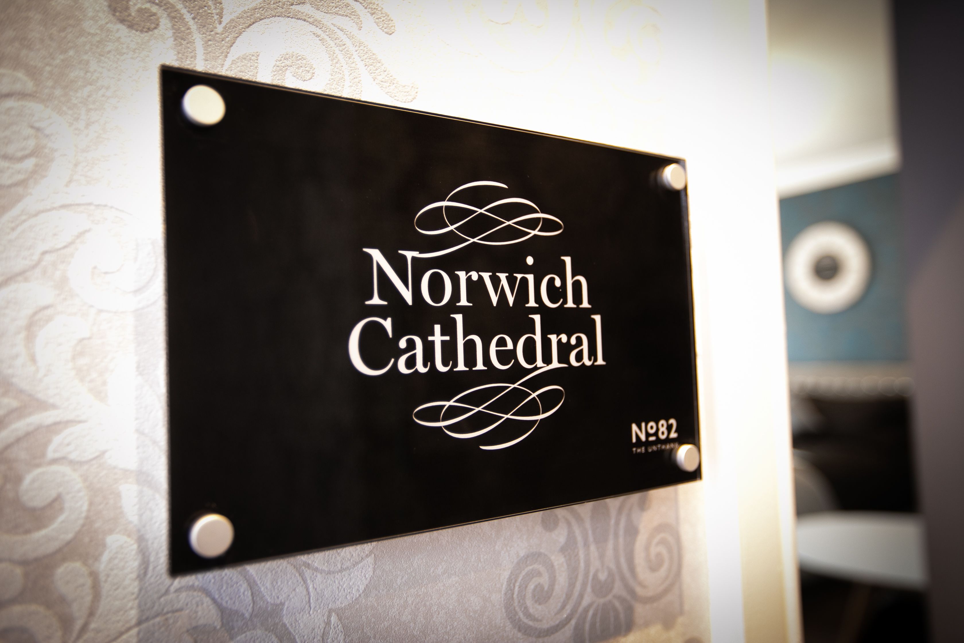 A sign with the text 'Norwich Cathedral' and the year '1982' on a wall.