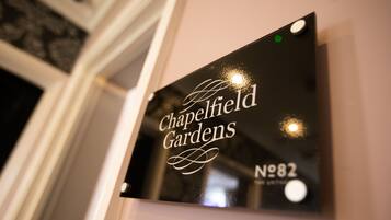 A sign with the text "Chapelfield Gardens" and "No. 82" on a wall.