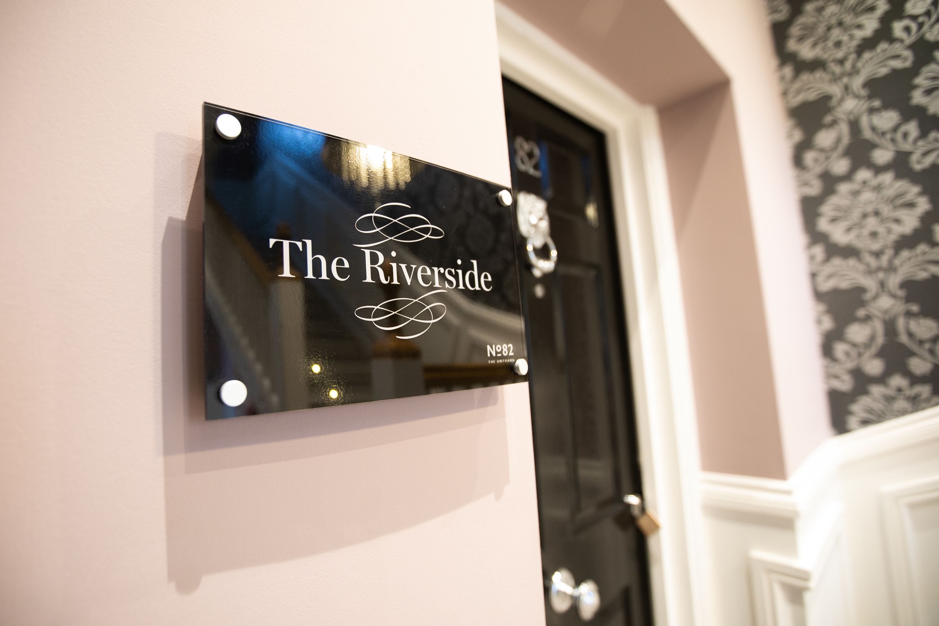 A sign with "The Riverside" and a number "82" on a wall.
