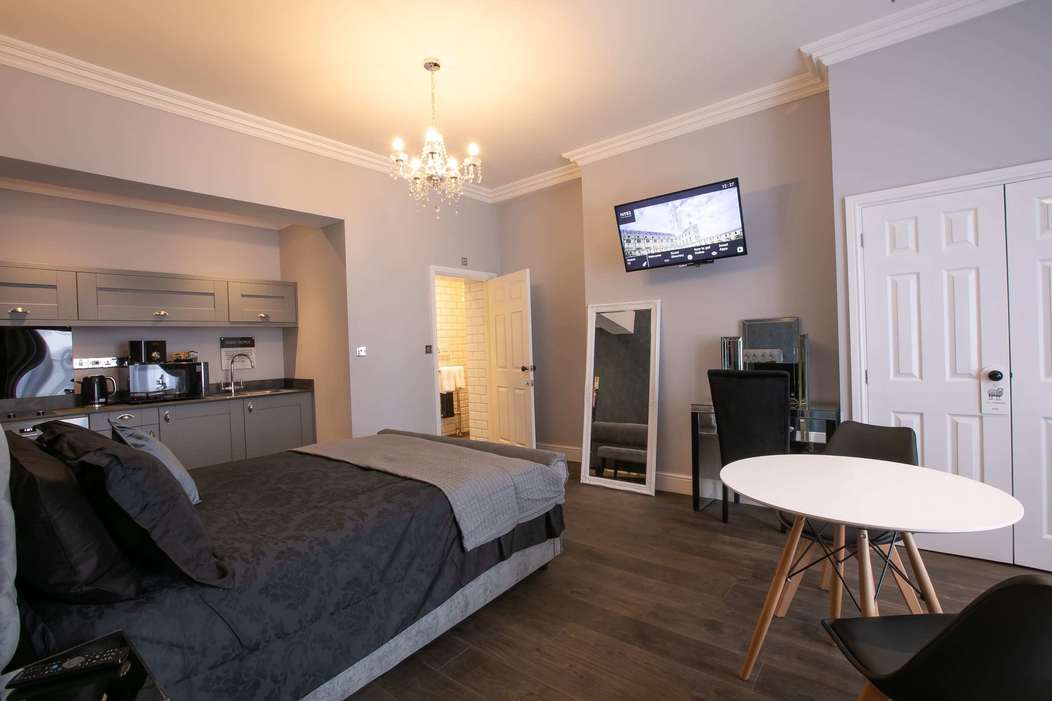 Une chambre d’hôtel moderne équipée d’un lit, d’une table à manger, d’une télévision et d’une kitchenette.