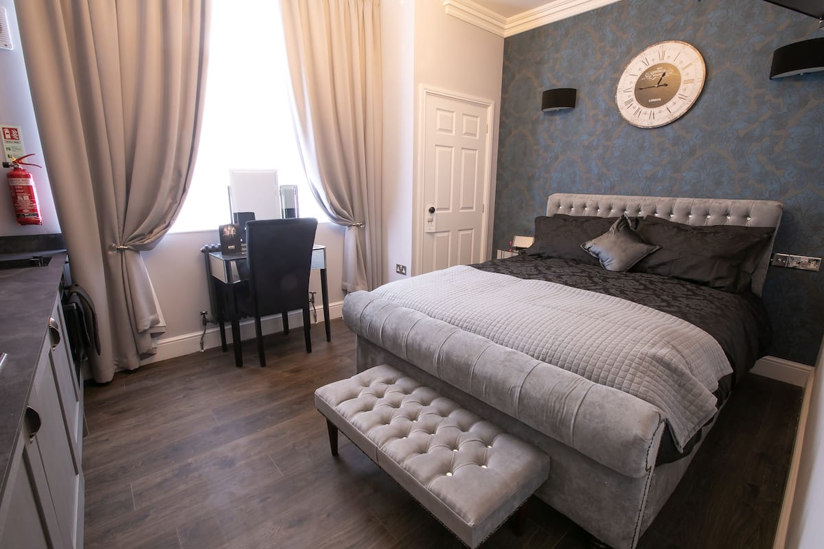 Un dormitorio con cama, escritorio y silla.