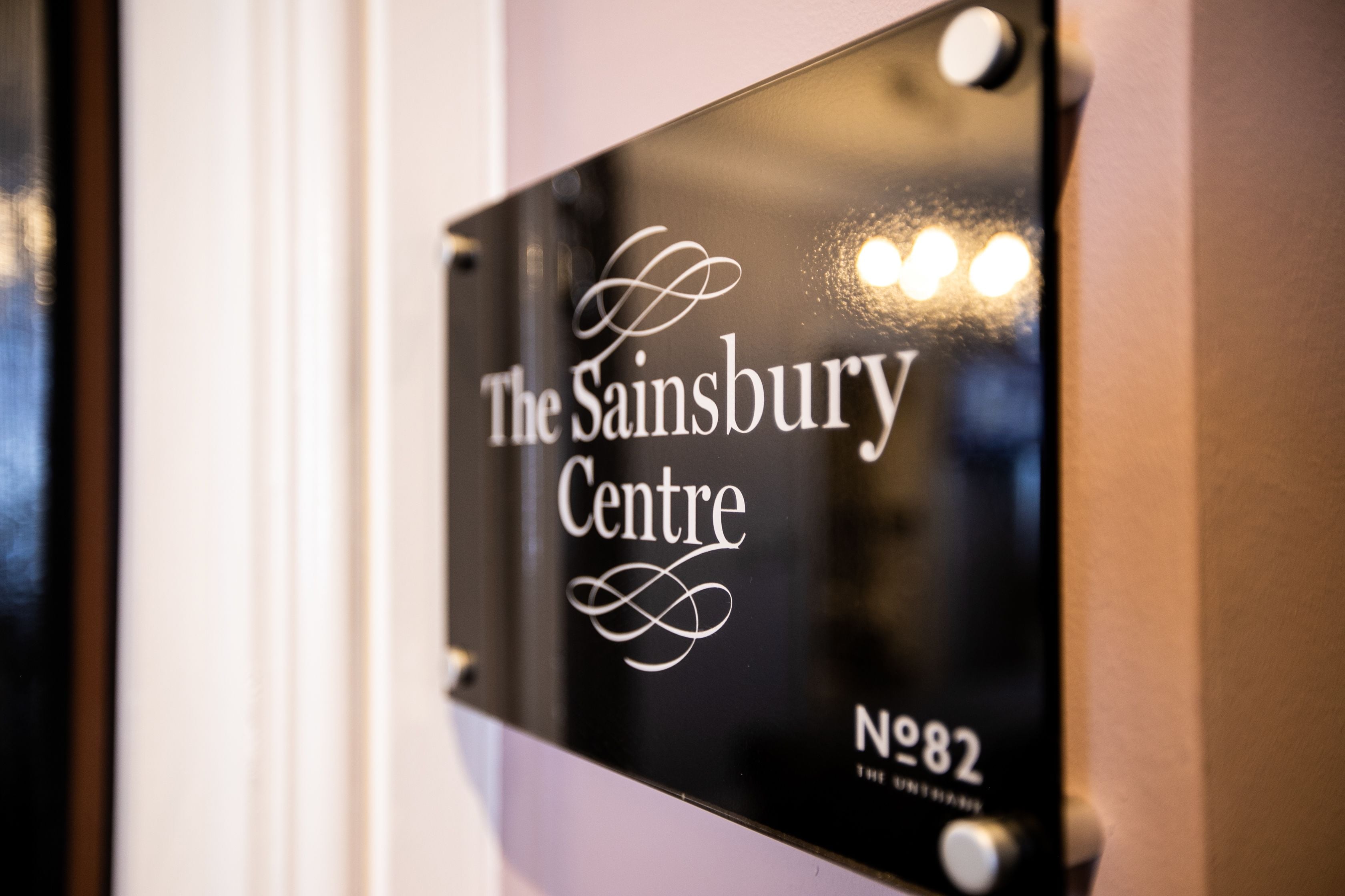 En skylt för Sainsbury Centre, nummer 82, med ett dekorativt typsnitt och ett nummer.