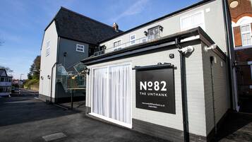 A building with a sign reading "N82 The Unthank" and a staircase leading to an upper level.