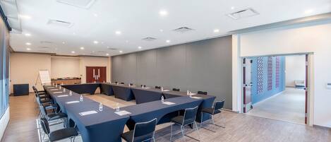 A conference room with a long table, chairs, and a whiteboard.