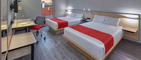 A hotel room with two beds, a desk, and a chair.