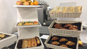 A breakfast buffet with various pastries, fruits, and bread. - Adrianus Hotel (Rome)