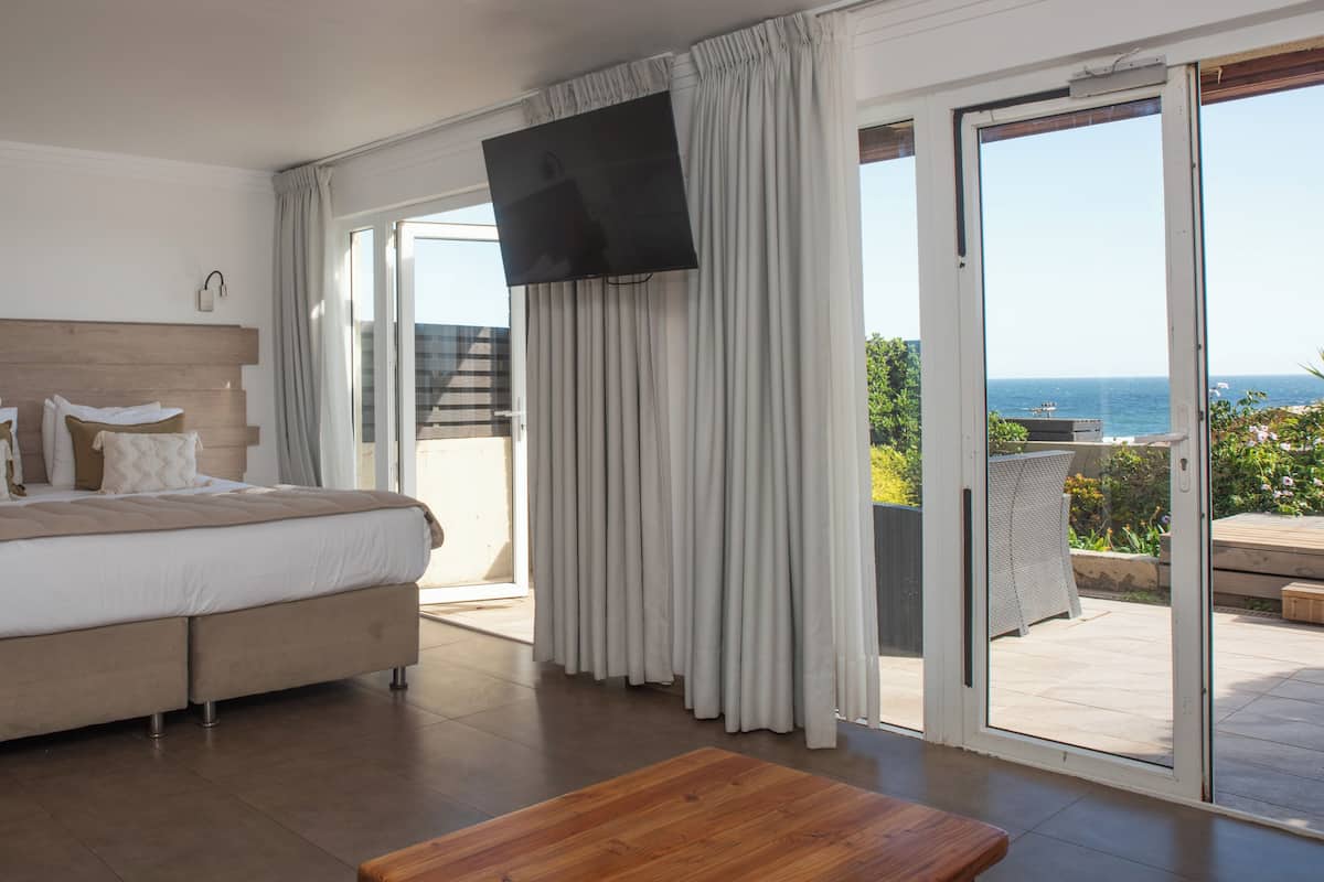 Un dormitorio con cama, televisión y vistas al exterior.
