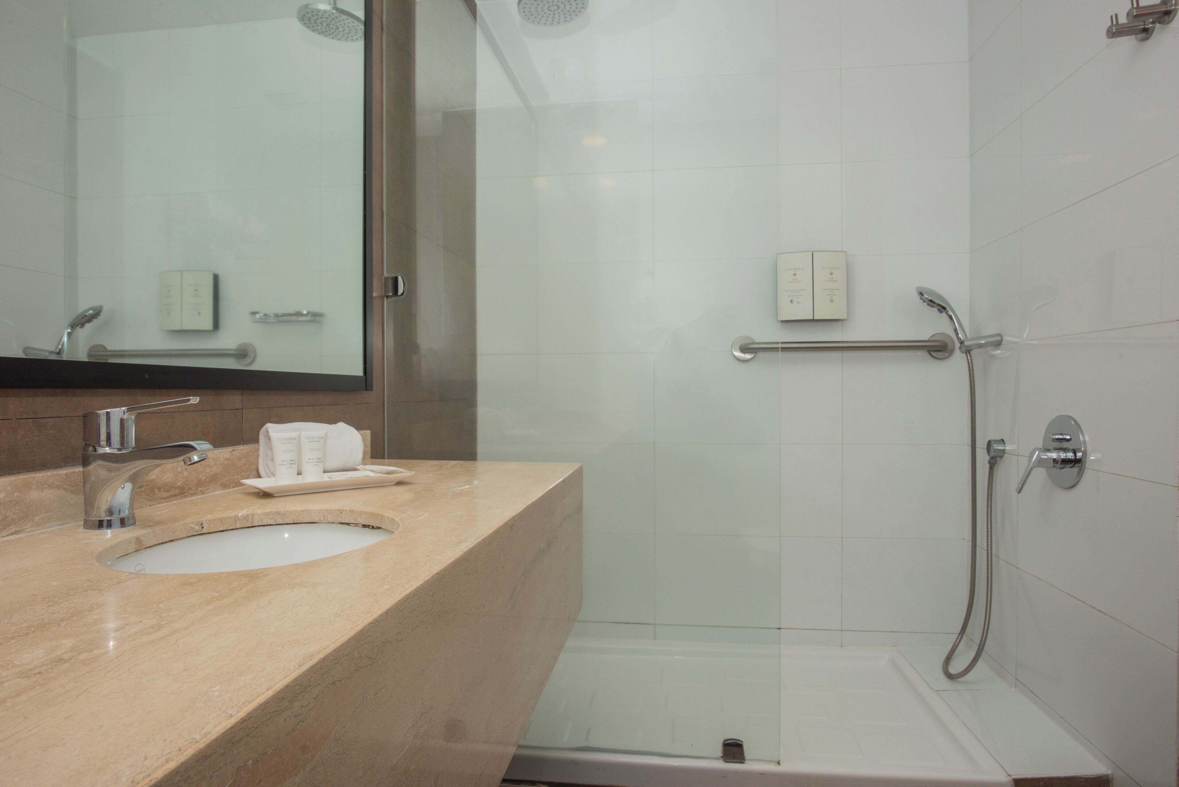 Une salle de bain moderne avec un lavabo, un miroir et une douche.