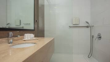 Une salle de bain moderne avec un lavabo, un miroir et une douche.
