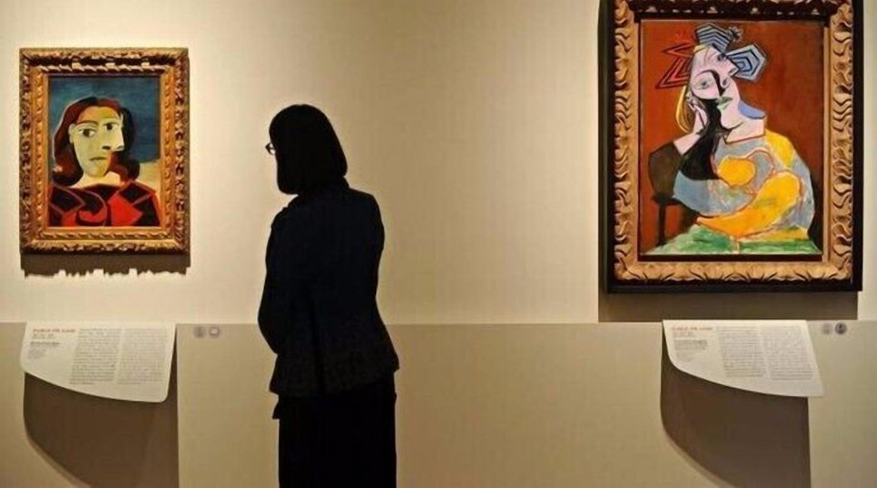A person viewing artworks in an art gallery.