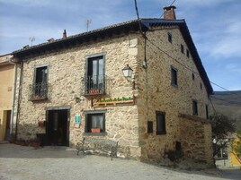 Un edificio de piedra con un letrero que dice "La Posada de los Vientos".
