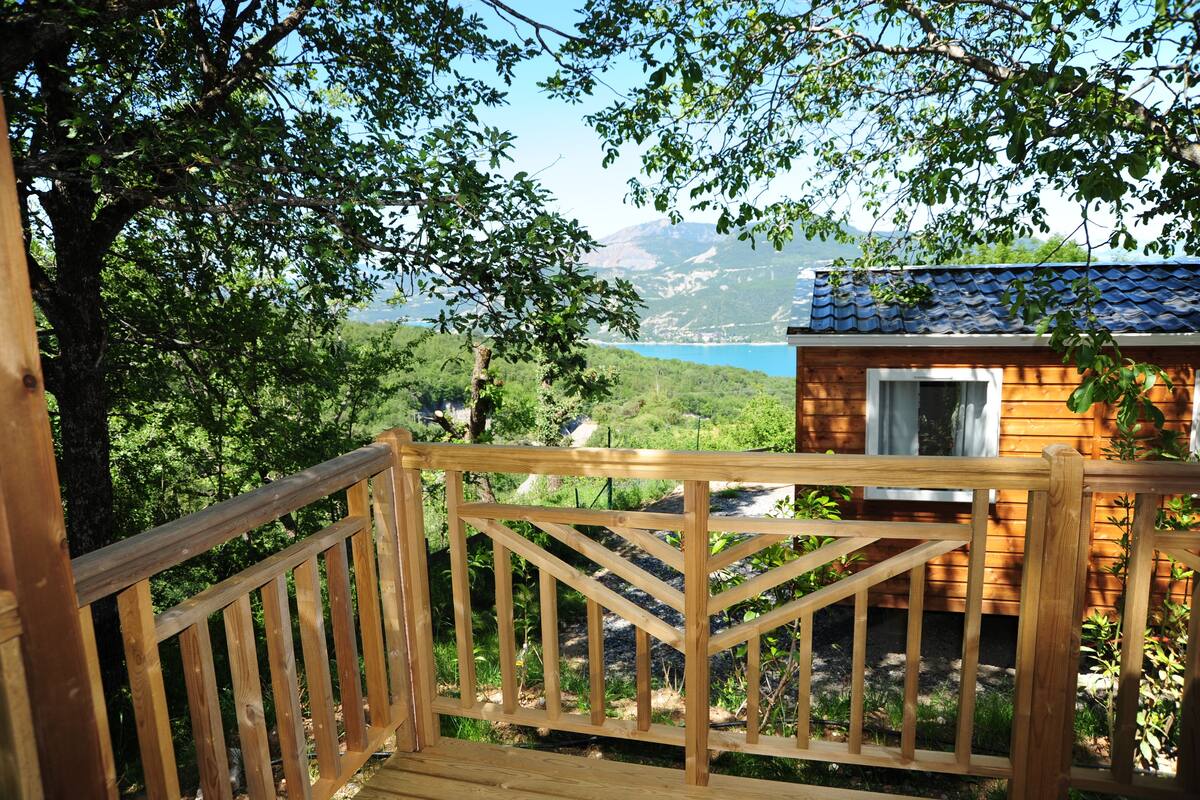Een houten terras met uitzicht op een berg en een meer.