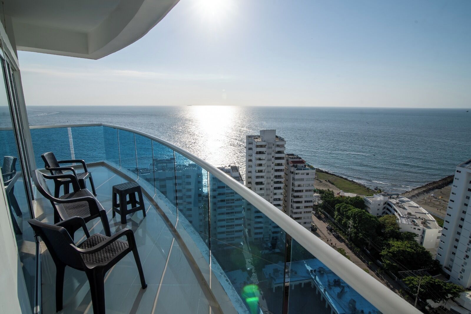 A balcony with a view of the ocean and cityscape.