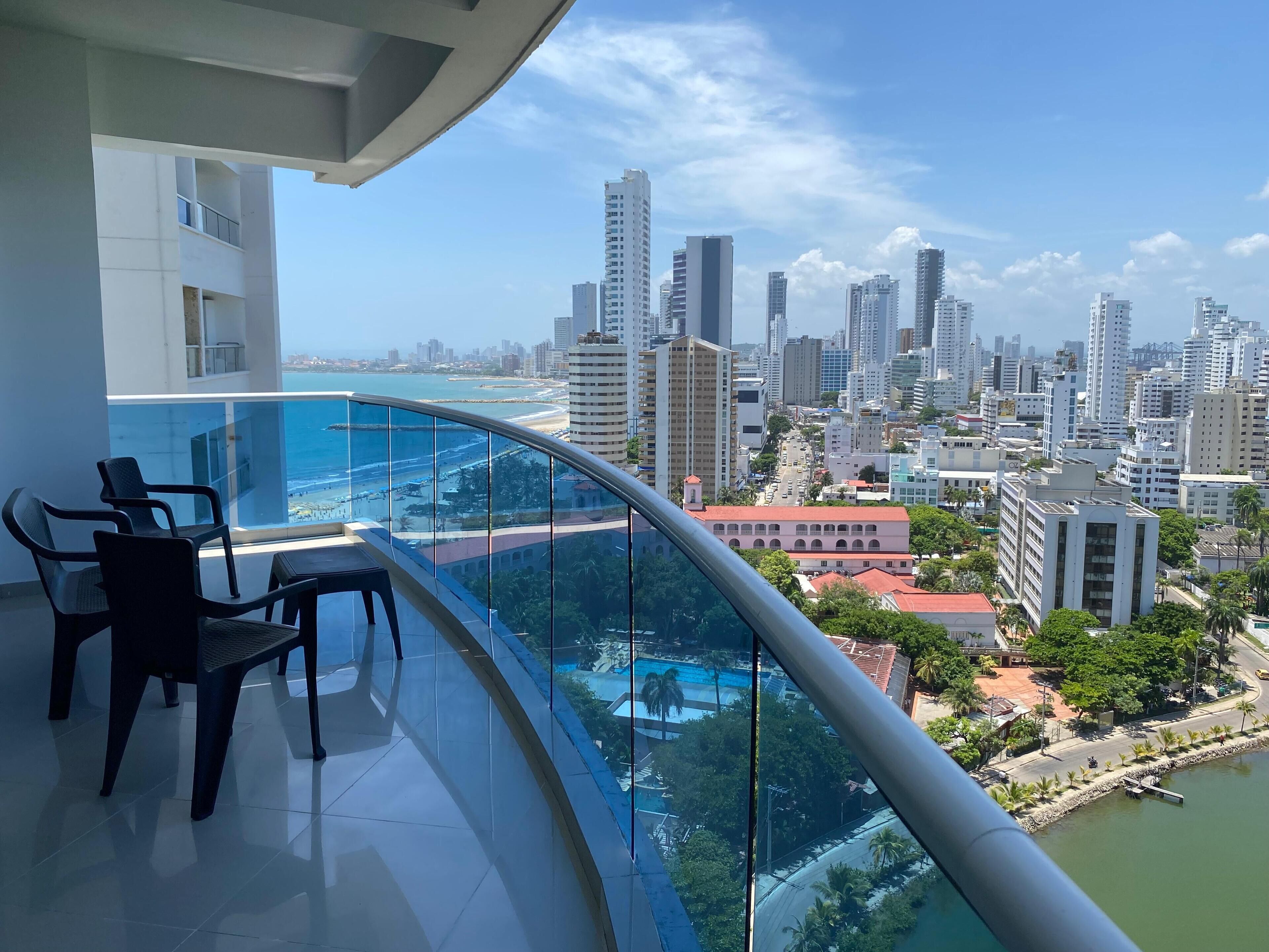 A balcony with a view of a cityscape and a beach.