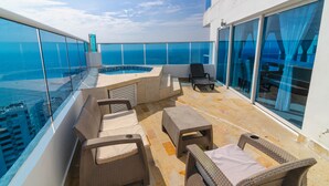 A rooftop terrace with wicker furniture, a swimming pool, and a view of the ocean. - Apartamentos Unik Cartagena Edificio Poseidón (Cartagena)