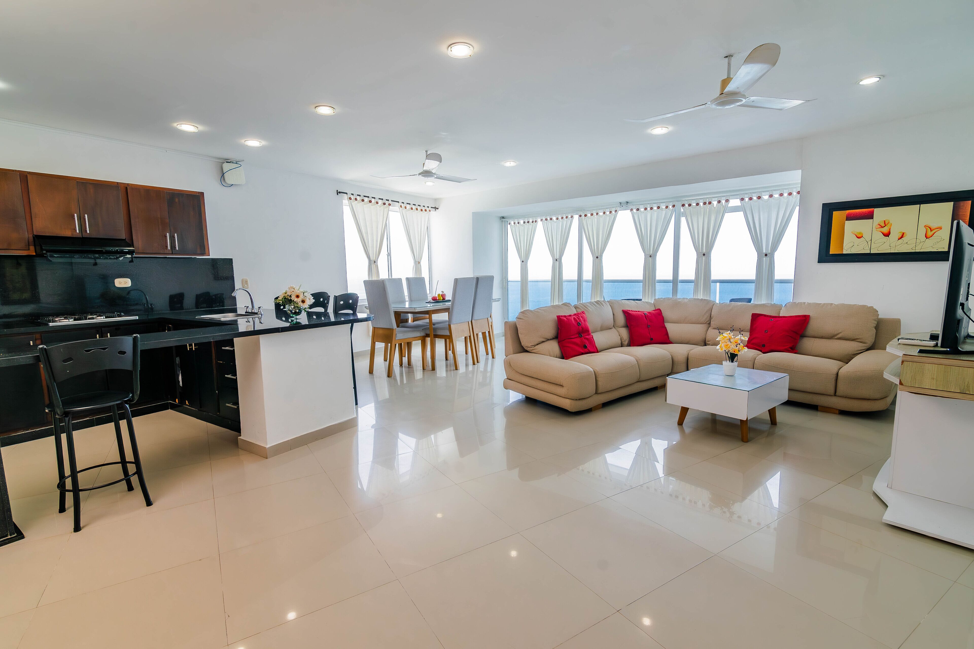 A modern living room with a sofa, coffee table, and dining area.