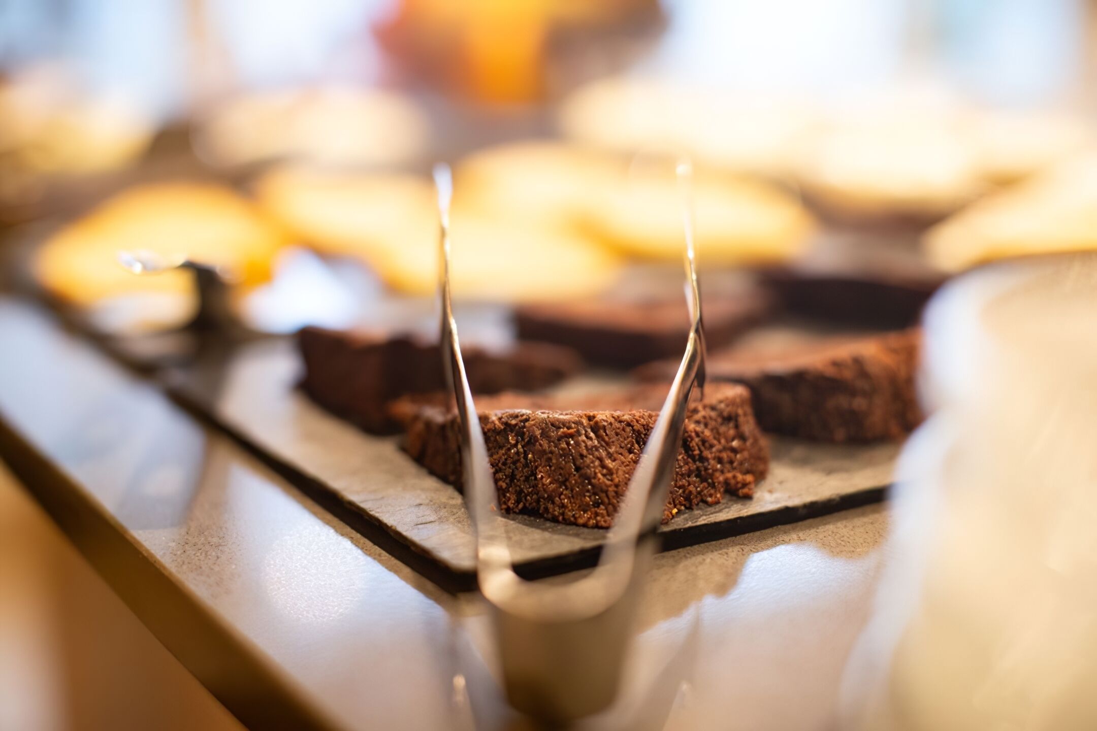 Una bandeja de brownies sobre una superficie reflectante.