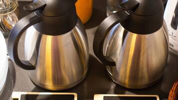 Dos cafeteras de acero inoxidable sobre una encimera, con etiquetas que dicen 'LECHE' y 'CAFE'.