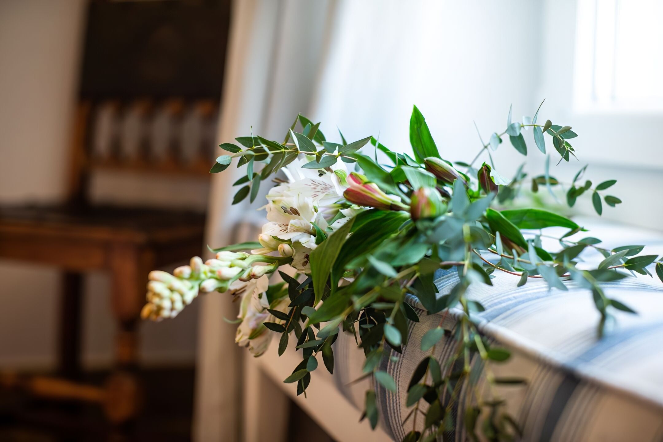 En blomsterbuket på et bord med et iøjnefaldende ternet dug.