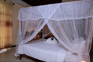 A bed with a white canopy and a swan-shaped pillow.