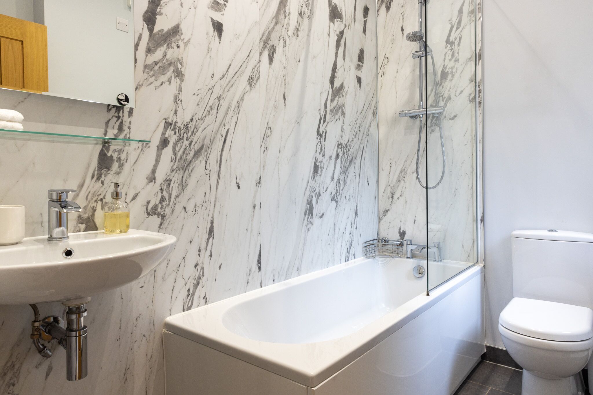 Une salle de bain avec une baignoire blanche, un lavabo et des toilettes.