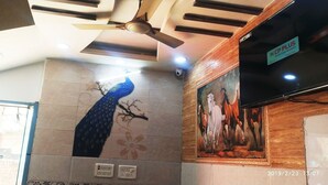 Un ventilateur de plafond, un enregistreur vidéo numérique et un tableau représentant des chevaux.
