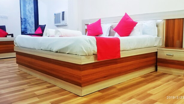 Une chambre moderne avec un lit en bois, une table de chevet et une petite table d’appoint.