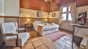A cozy hotel room with a bed, a desk with a computer, a chair, and a TV. - Esquilo Hotel (Camanducaia)