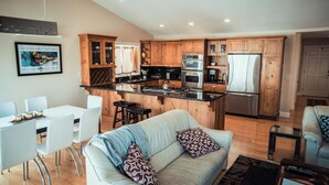 Una cocina moderna con armarios de madera, electrodomésticos de acero inoxidable y una isla central.