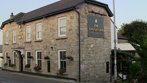 A stone building with a sign reading "The Badger Inn" and a no entry sign.