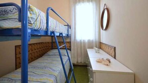 Una stanza con letti a castello, una scrivania e una finestra con tende.