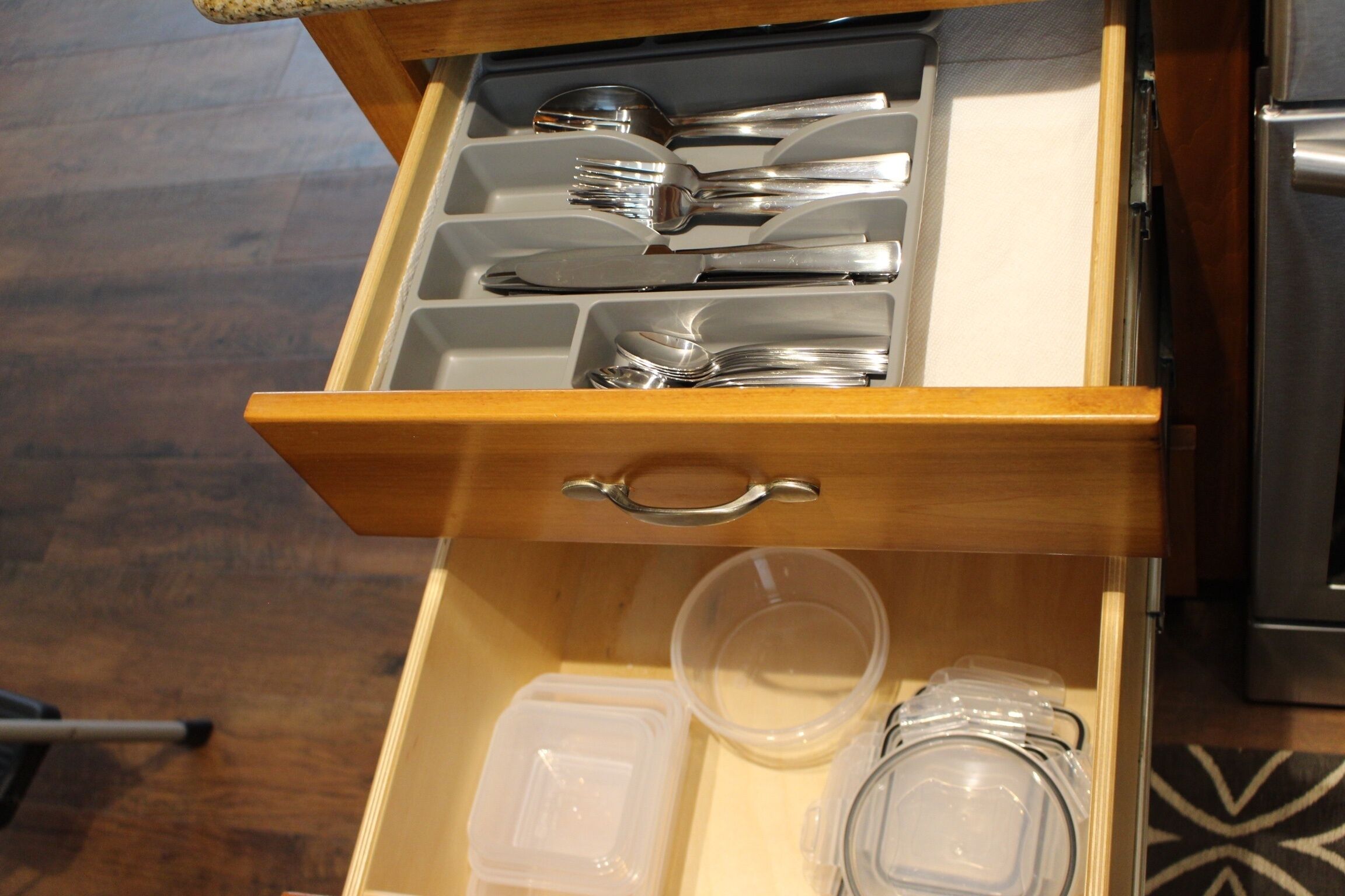 A drawer with utensils and containers, likely in a hotel or similar accommodation.