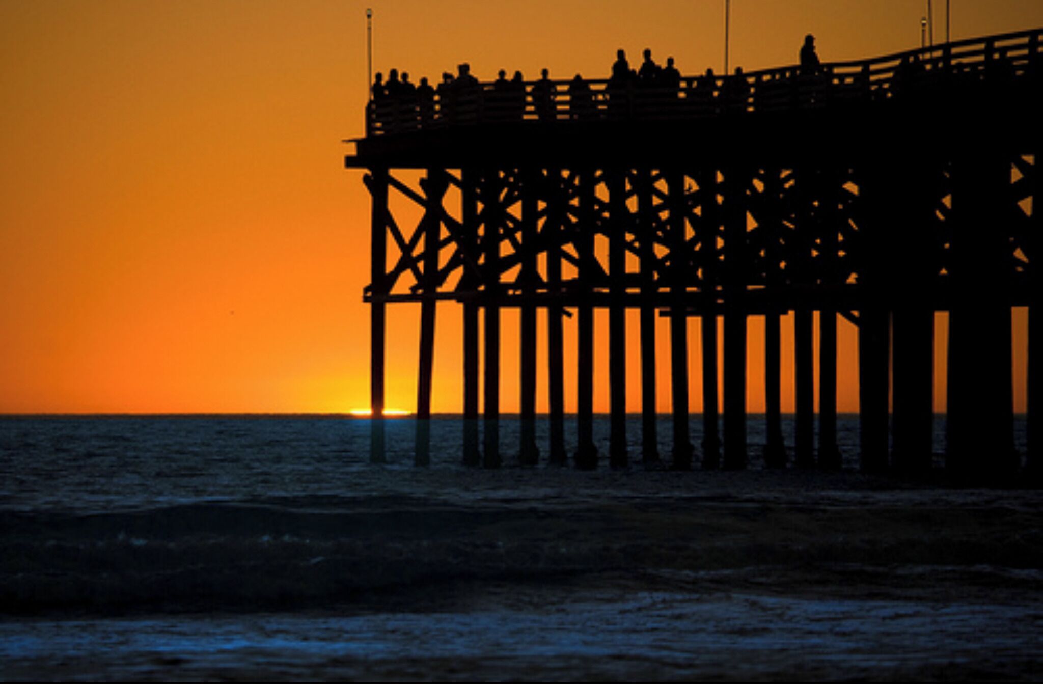 A pier extending into the water during sunset.