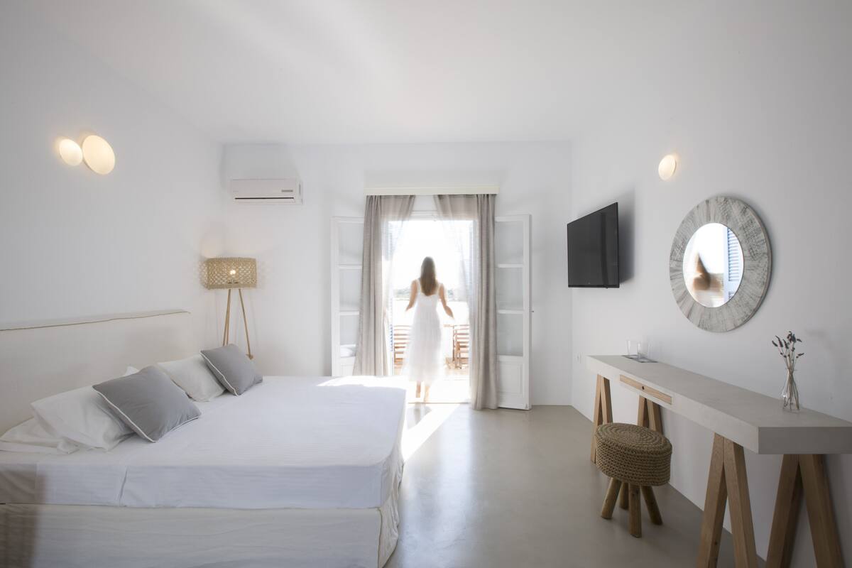A bedroom with a bed, bedside table, and a desk with a chair.