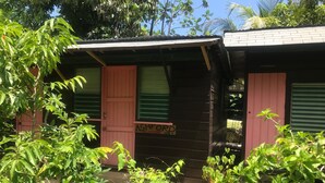 A rustic wooden building with a sign reading "ASHFORD HOUSE No.1". - Secret Cabins at Firefly Beach (Negril)