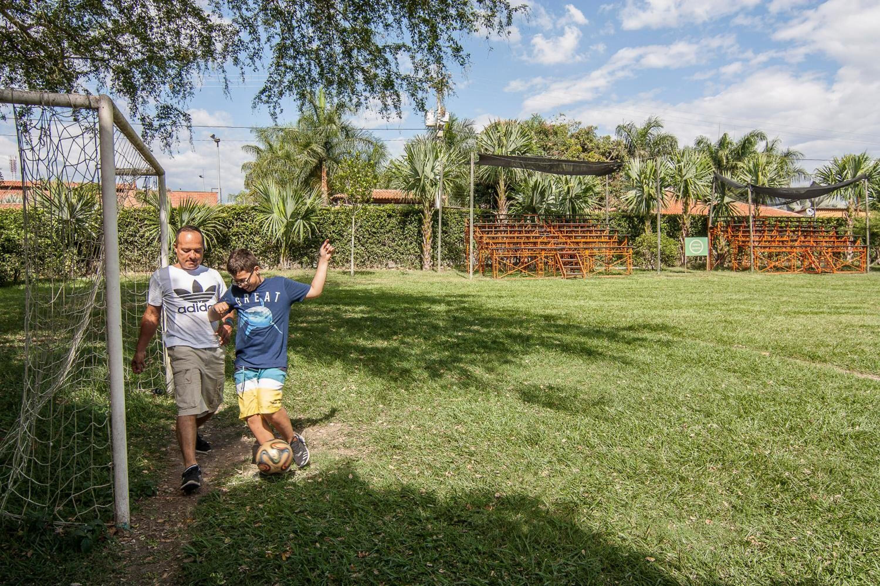 Un espace extérieur enherbé avec un but de football, un filet et une clôture.
