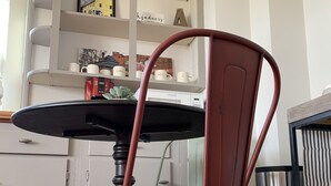 En rød metalstol med et sort bord i et køkken.
